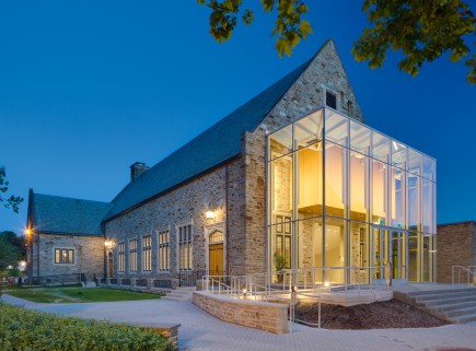 The modern glass entry addition provides an obvious contrast to the Butler Stone building with vertical proportions that respond to the
Gothic context utilizing standard construction.-Friends School of Baltimore Performing and Visual Arts Center